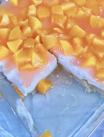 Homemade peach cheesecake in a clear 9x13 pan